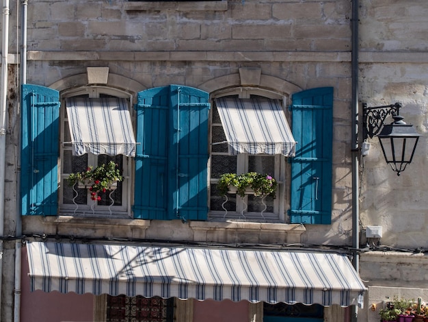 Dos ventanas en una casa de piedra con persianas azules