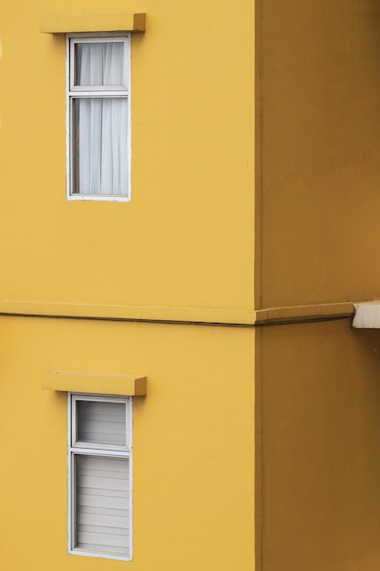 Dos ventanas en la pared amarilla de un apartamento.