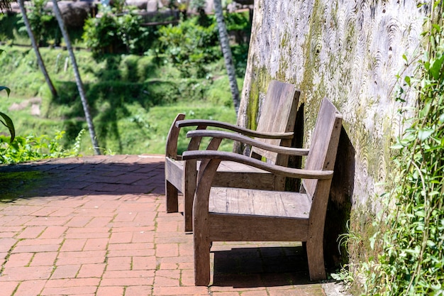 Dos viejas sillas de madera en un jardín tropical para relajarse en la naturaleza, la isla de Bali, Indonesia. De cerca