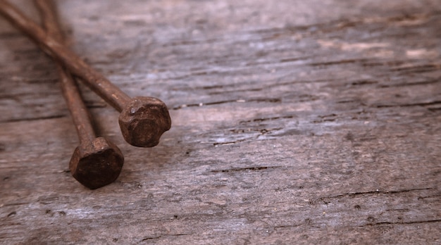Dos viejos clavos oxidados descansan sobre una madera