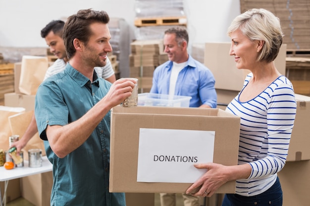 Dos voluntarios sosteniendo una caja de donaciones