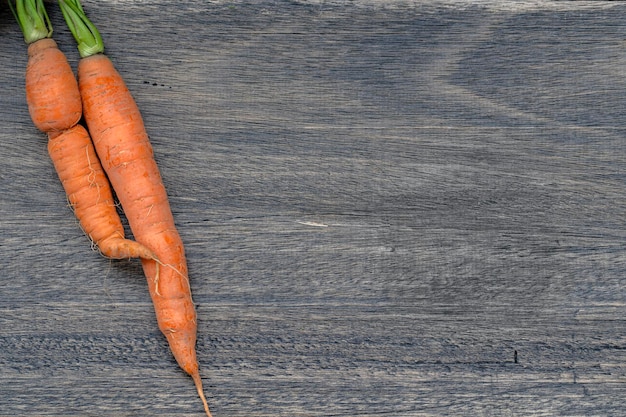 Dos zanahorias orgánicas sobre una mesa de madera