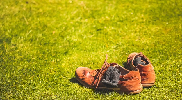 Dos zapatos y calcetines sobre la hierba.