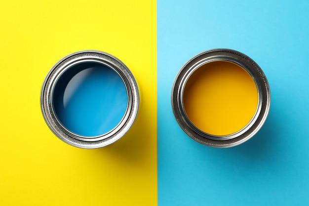 Dosen mit blauer und gelber Farbe auf zweifarbiger Oberfläche