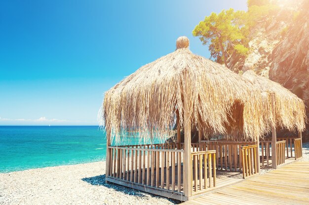 Dossel com telhado de palha na praia em Kemer, Turquia. Paisagem de verão