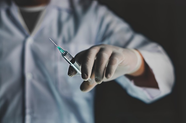 Foto doutor de perto segurando seringa do frasco e mãos com vacinação e imunização de medicamentos