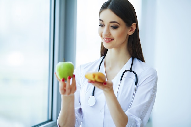 Foto doutor dietitian standing perto da janela no escritório claro.