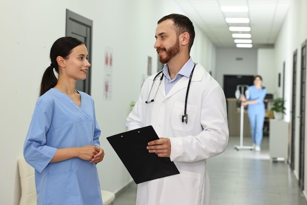 Doutor e enfermeira a falar no corredor do hospital.