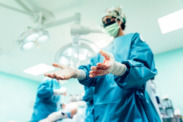 Doutor mostrando mãos manchadas na sala de cirurgia