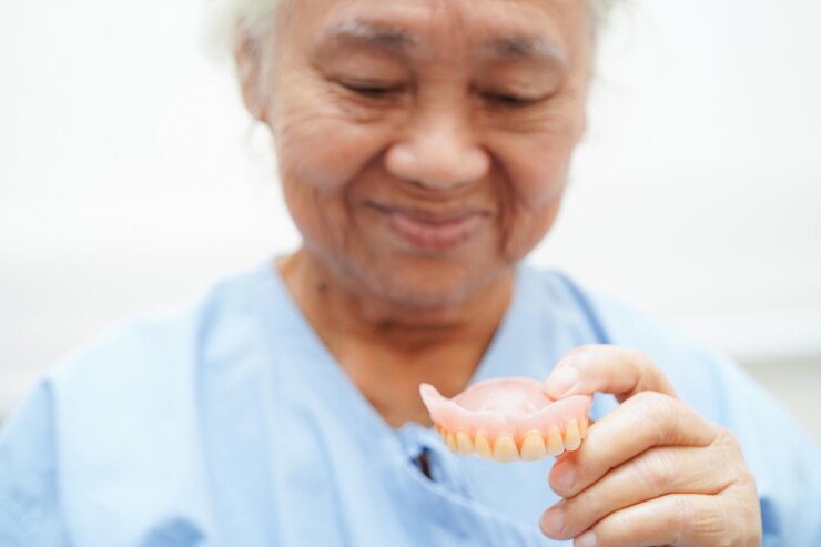 Foto doutor segurando dentadura dentária na mão para dentista estudando odontologia