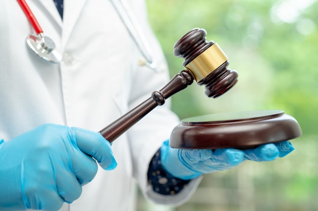 Doutor segurando martelo de juiz medicina forense lei médica e conceito de justiça criminal