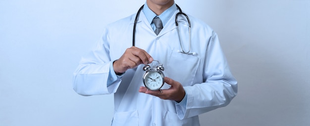 Foto doutor, segurando um relógio, conceito de tempo, medicina e saúde
