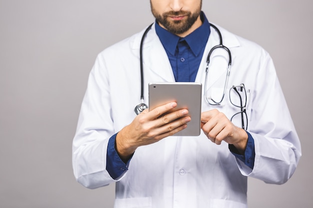 Doutor sorridente usando um computador tablet