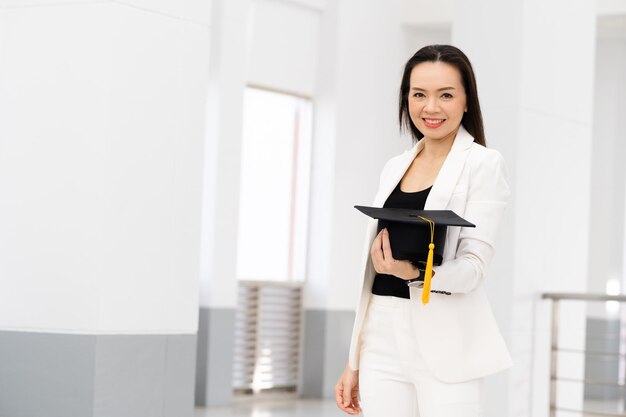 Doutorandos do sexo feminino usando bonés de formatura de borla amarela preta estão na universidade.