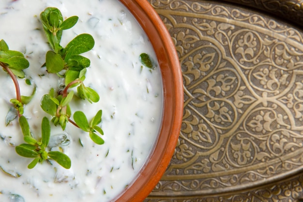 Dovga en el tablero de madera Comida nacional de azerbaiyán Sopa cremosa dovga Sopa azerbaiyana Dovga con verduras en un tazón blanco