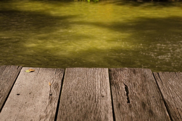 Download holzbrett tisch vor sommerlandschaft von sprudelnden see wasser