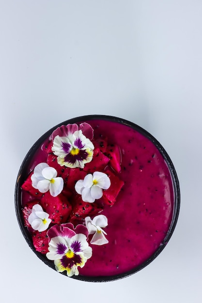 Drachenfrucht-Lassi-Joghurt oder Smoothie mit Drachenfruchtgarnitur mit essbaren Blüten