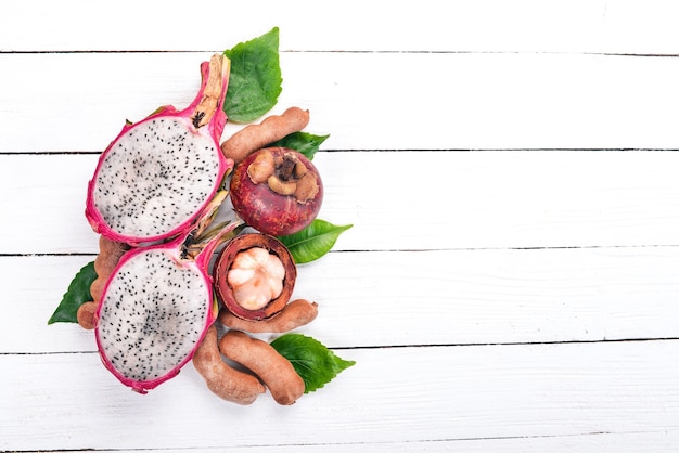 Drachenfrucht Rambutan und Mangosteen Frische tropische Früchte auf einem hölzernen Hintergrund Ansicht von oben Kopieren Sie Platz