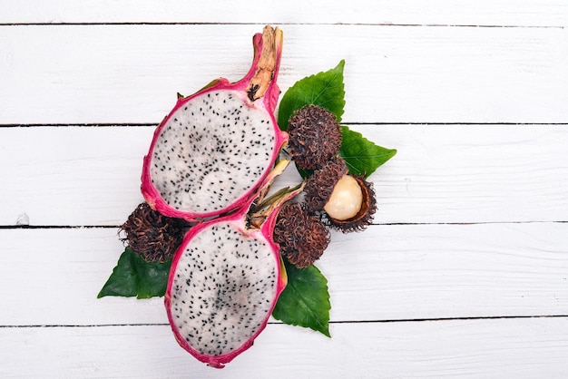 Drachenfrucht und Rambutan Frische tropische Früchte auf einem hölzernen Hintergrund Ansicht von oben Kopieren Sie Platz