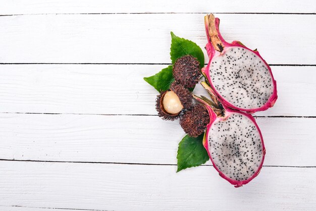 Drachenfrucht und Rambutan Frische tropische Früchte auf einem hölzernen Hintergrund Ansicht von oben Kopieren Sie Platz