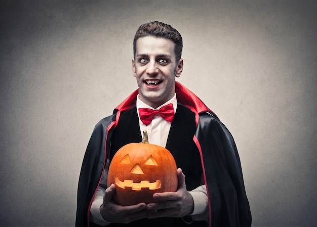 Foto drácula de miedo con una calabaza