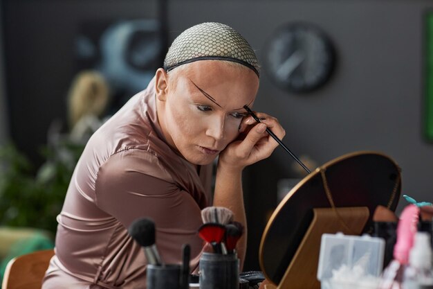 Drag queen haciendo maquillaje en el camerino