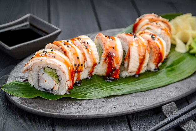 Dragão de rolo de sushi com enguia defumada e camarão Rolo de sushi fresco delicioso tradicional em um fundo preto Menu de sushi Restaurante de cozinha japonesa Comida asiática