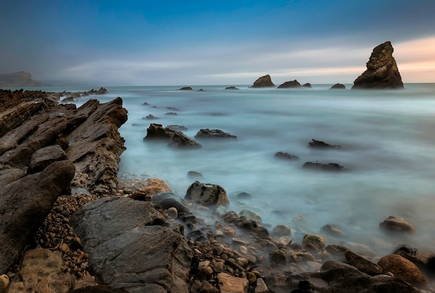 Dragon Mupe Rocks y Mupe Bay Cliff. Agujero de tocino al atardecer. Dorset Inglaterra. REINO UNIDO. Exposición prolongada