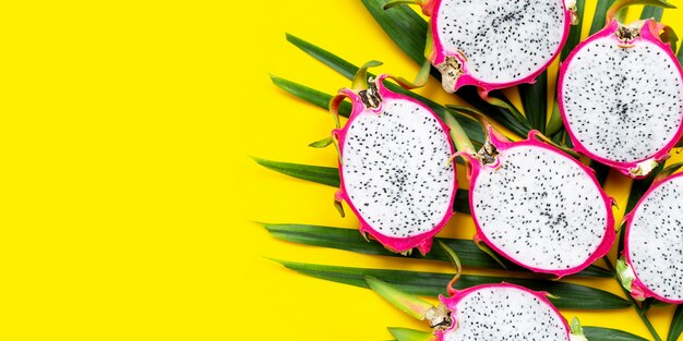 Dragonfruit maduro ou pitaya em folhas de palmeira tropical.
