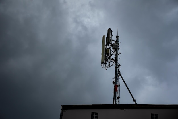 Drahtlose Technologie des Telekommunikationsturms gegen graue Wolken vor Regensturm