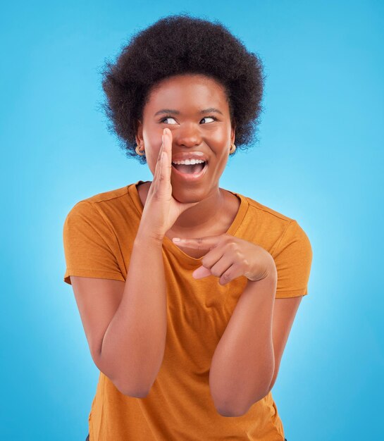 Drama de mujer negra y chismes secretos en el estudio compartiendo emocionantes noticias confidenciales sobre fondo azul Susurro de anuncio de trato y niña africana feliz con discusión afro aislada en privacidad