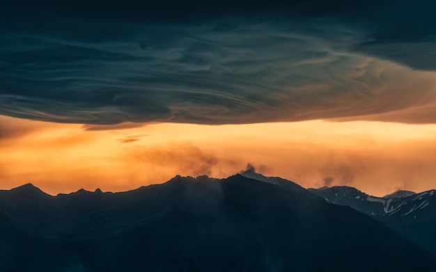 Dramático do céu colorido do pôr do sol e da nuvem Asperitas sobre a montanha islandesa na Islândia