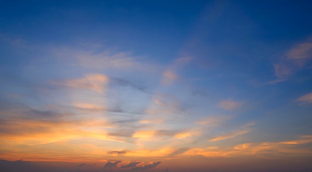 Dramático fondo del cielo del atardecer con majestuosa luz solar amarilla con nubes en el crepúsculo azul oscuro