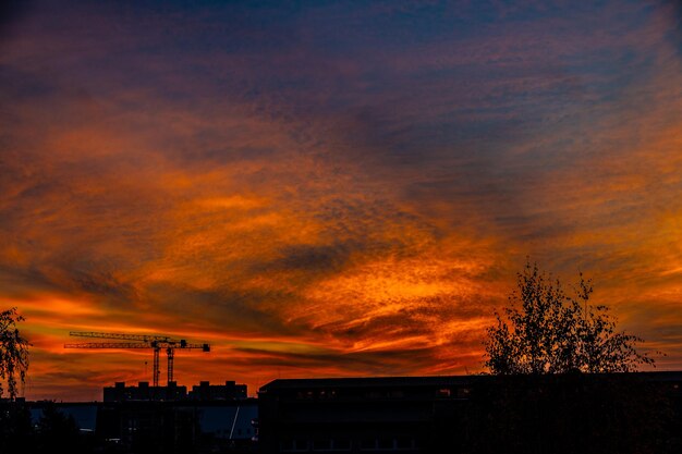 Foto dramático natural com nuvens colorido pôr-do-sol urbano com guindaste de construção