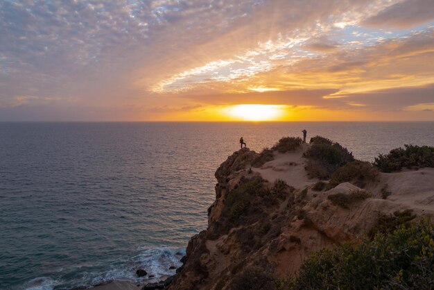 Dramático paisaje marino de roca escénica Puesta de sol del océano sobre fondo de cielo con nubes de colores Mar en calma con el cielo del amanecer