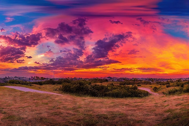 Dramatischer Himmel des rosa Sonnenuntergangs über großem Feld