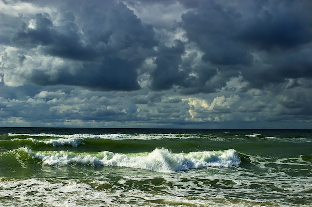 Dramatischer Himmel mit dunklen Wolken und stürmischer See mit rollenden Wellen