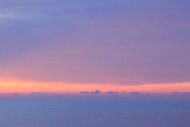 Dramatischer minimalistischer pastellfarbener Sonnenuntergangshimmel und tropisches Meer