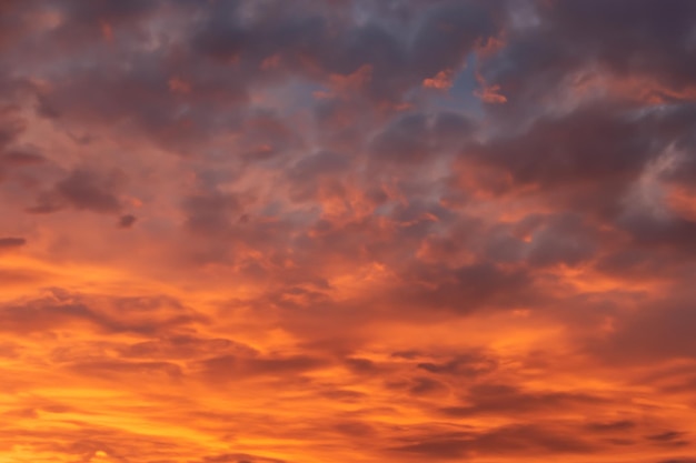 Dramatischer orangefarbener und grauer Sonnenuntergangshimmel mit dicken Wolken