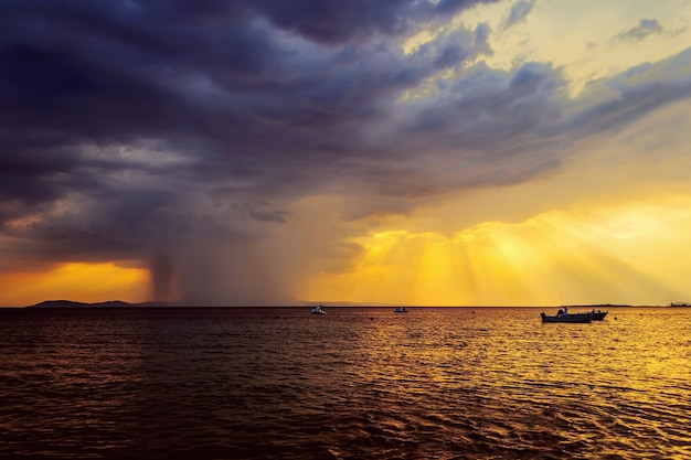 Dramatischer Sonnenuntergang und bevorstehender Regensturm auf See