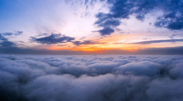 Dramatischer Sonnenuntergangshimmel über den flauschigen Wolken aus der Luftansicht. Schöne Wolkenlandschaft.