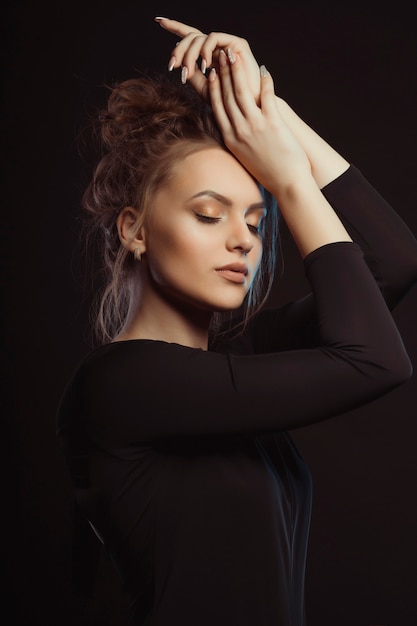 Dramatisches Porträt der schönen Frau im Schatten im Studio