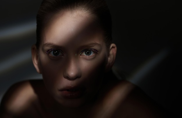 Dramatisches Porträt einer Frau mit Lichtern und Schatten auf ihrem Gesicht.