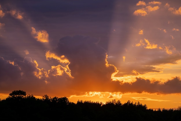 Dramatisches Sonnenuntergangshimmelpanorama mit brennenden bunten Wolken.