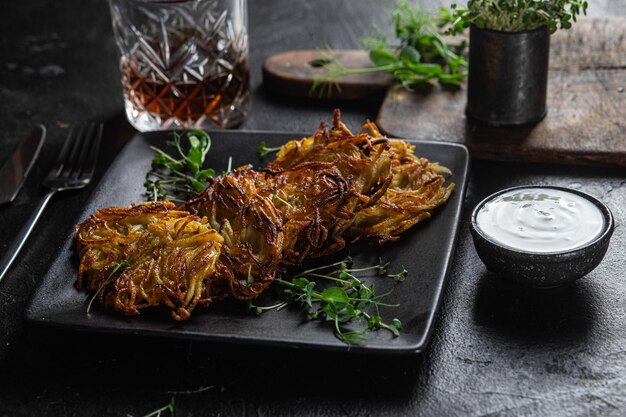 Foto draniki panqueques de patatas con salsa de ajo