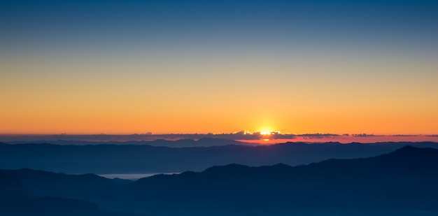 Drastischer Sonnenuntergang- und Sonnenaufganghimmel des Landschaftspanoramas auf Gebirgsschicht
