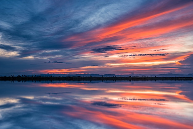 Drastischer Sonnenunterganghimmel mit Wolken über Meer.