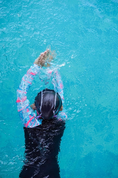 Draufsicht Asiatisches Kind kleines Mädchen lernt im Schwimmbad schwimmen