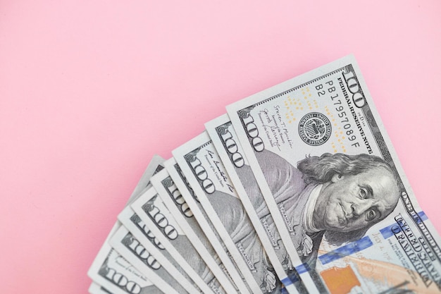 Draufsicht auf Bündel von 100-Dollar-Scheinen auf rosa Hintergrund Geschäftskonzept mit Kopierbereich