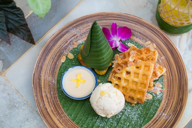 Draufsicht auf Butterwaffel mit Bananencreme suace und Eiscreme